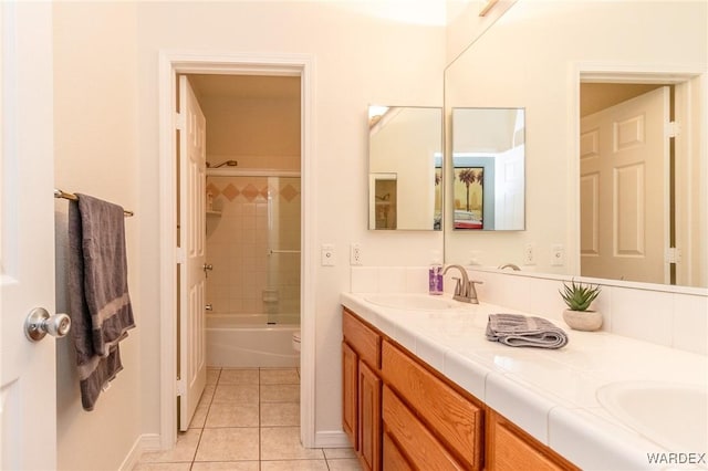 full bath with double vanity, shower / bathing tub combination, a sink, tile patterned floors, and toilet