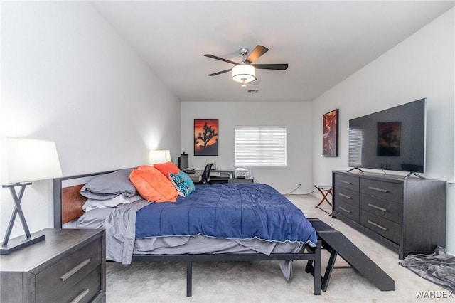 bedroom featuring light colored carpet and a ceiling fan