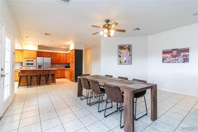 dining room featuring light tile patterned floors, visible vents, and ceiling fan