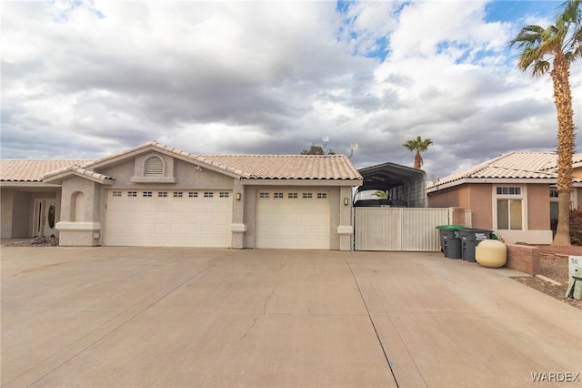 view of front of home with a carport, stucco siding, an attached garage, and driveway