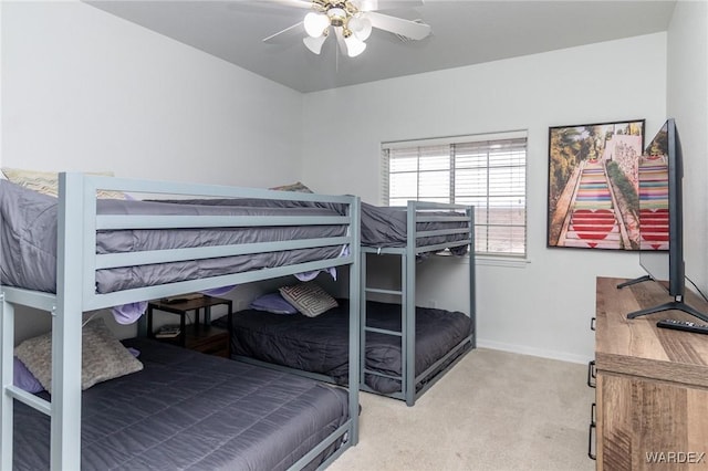 bedroom with light colored carpet, baseboards, and ceiling fan