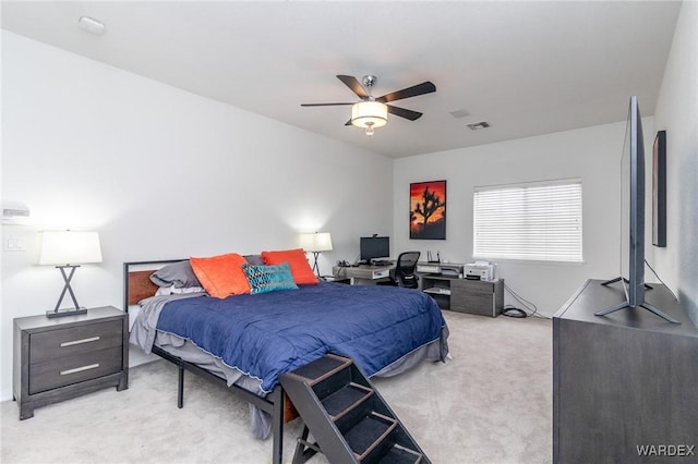 bedroom with visible vents, light colored carpet, and a ceiling fan