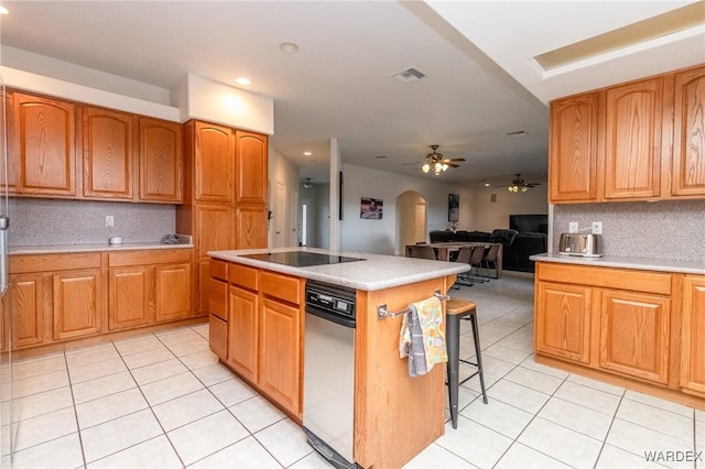 kitchen featuring a kitchen island, light tile patterned flooring, arched walkways, decorative backsplash, and black electric stovetop