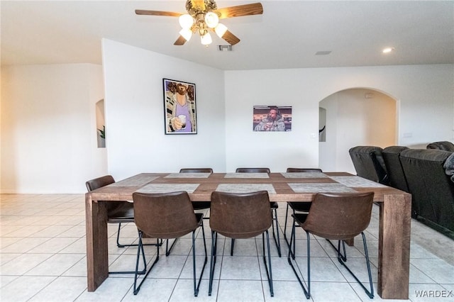 dining area featuring visible vents, arched walkways, light tile patterned flooring, and a ceiling fan