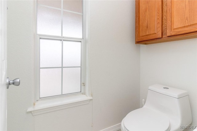 bathroom with toilet and baseboards