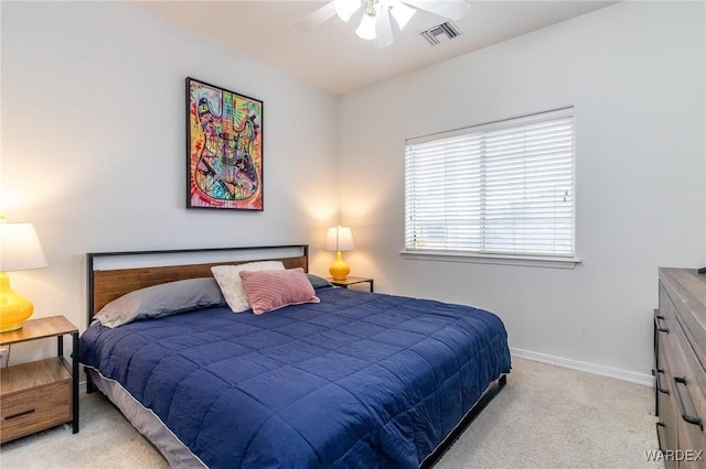 bedroom featuring visible vents, light colored carpet, a ceiling fan, and baseboards