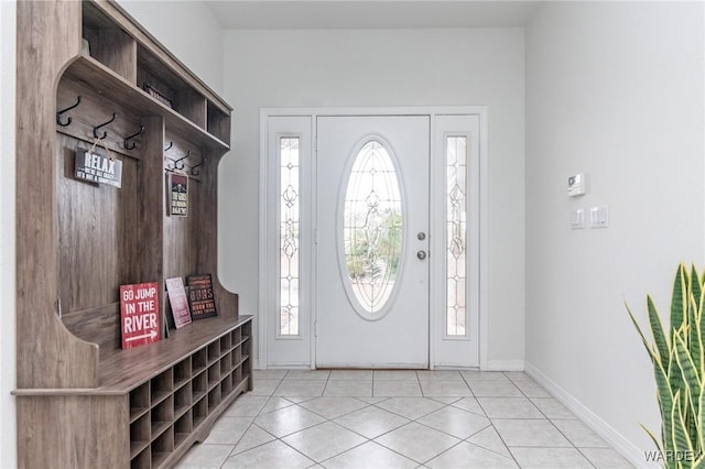 entryway with light tile patterned floors, a healthy amount of sunlight, and baseboards