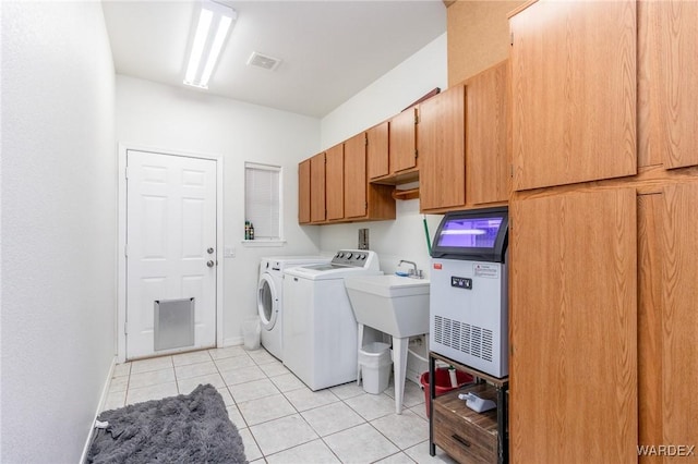 washroom with visible vents, baseboards, light tile patterned flooring, cabinet space, and washing machine and dryer