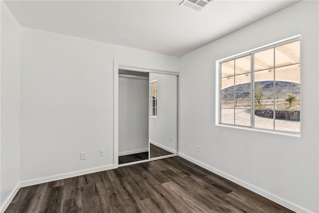 15565 Iron Dr, Dolan Springs, AZ 86441 - unfurnished bedroom featuring dark wood-style flooring and a closet