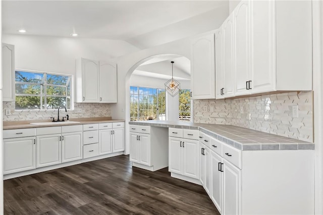 15565 Iron Dr, Dolan Springs, AZ 86441 - kitchen with vaulted ceiling, tile countertops, white cabinets, dark wood finished floors, and decorative backsplash