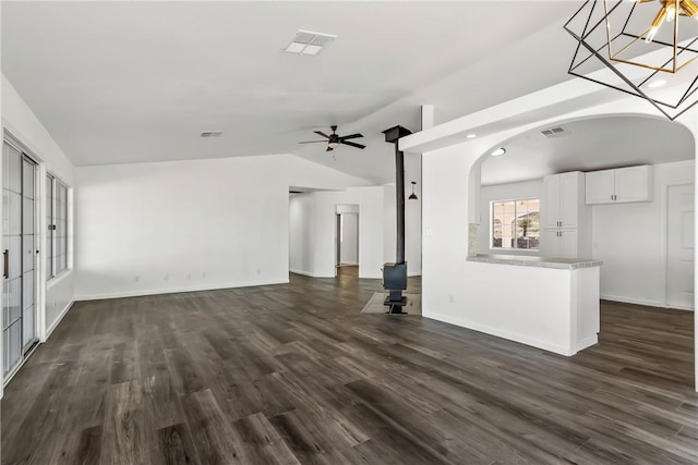 15565 Iron Dr, Dolan Springs, AZ 86441 - unfurnished living room with vaulted ceiling, a ceiling fan, dark wood-style flooring, and arched walkways