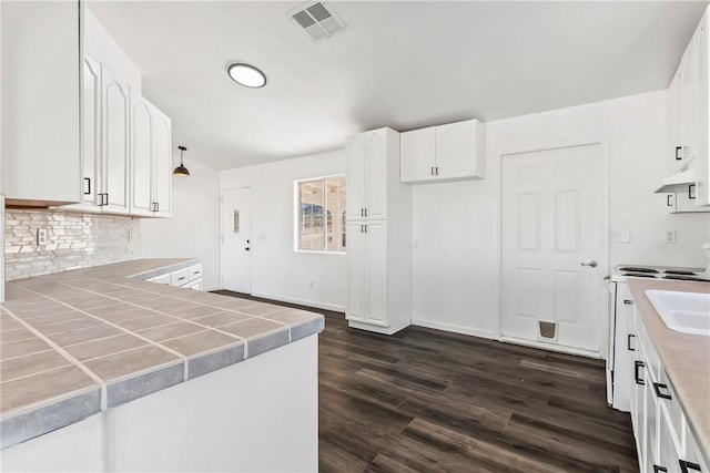 15565 Iron Dr, Dolan Springs, AZ 86441 - kitchen with backsplash, tile counters, white cabinets, dark wood finished floors, and a peninsula