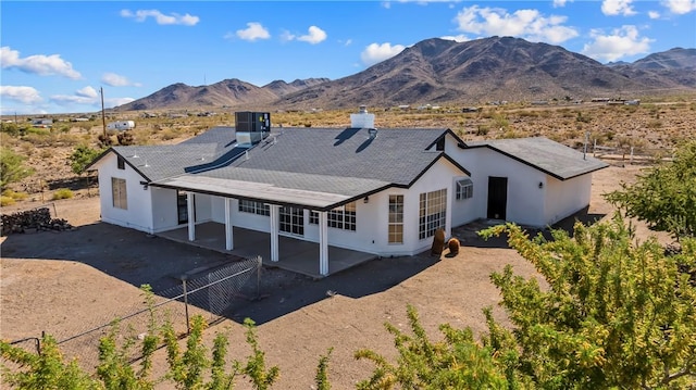 15565 Iron Dr, Dolan Springs, AZ 86441 - back of property featuring a mountain view, a patio, a chimney, stucco siding, and a shingled roof