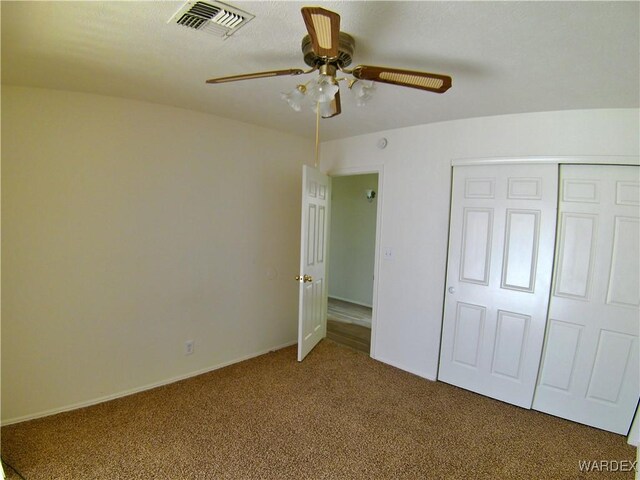 unfurnished bedroom featuring a ceiling fan, a closet, visible vents, and carpet flooring