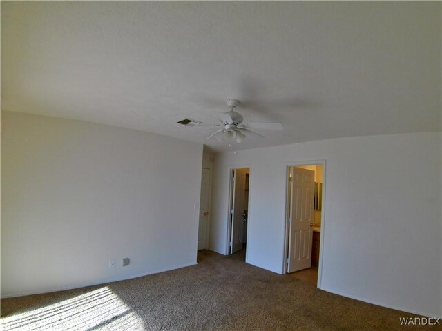 spare room with light carpet, visible vents, and a ceiling fan