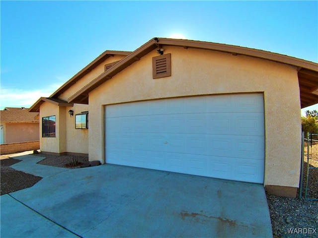 view of front of home featuring an attached garage, driveway, and stucco siding