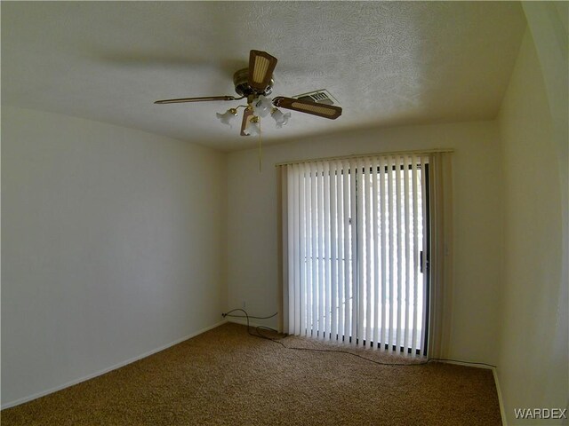 spare room featuring a textured ceiling, carpet, and a ceiling fan