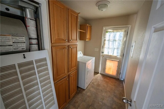 clothes washing area with washer / dryer and cabinet space