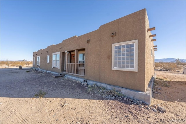 exterior space with a mountain view and stucco siding