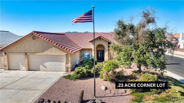 view of front facade featuring a garage, concrete driveway, a tiled roof, and stucco siding