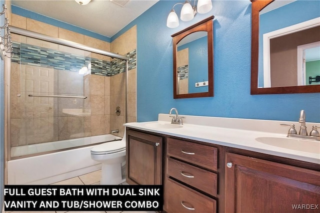 bathroom with combined bath / shower with glass door, tile patterned flooring, a sink, and toilet