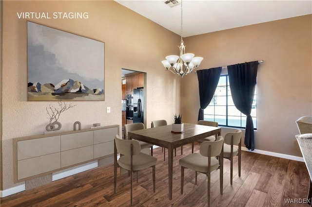 dining space featuring baseboards, wood finished floors, visible vents, and a notable chandelier