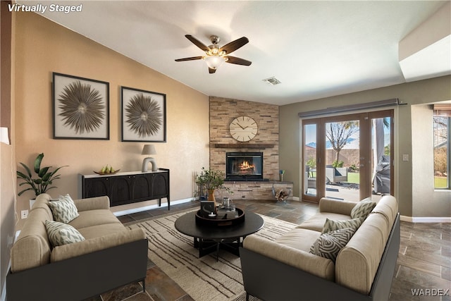 living room featuring lofted ceiling, a fireplace, visible vents, baseboards, and stone tile flooring