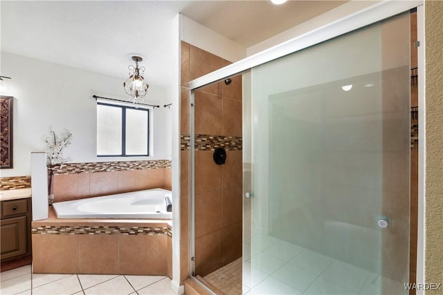 bathroom with tile patterned flooring, vanity, a bath, and a shower stall