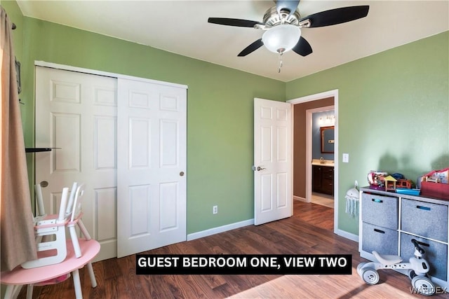 interior space with a closet, baseboards, dark wood finished floors, ceiling fan, and a sink