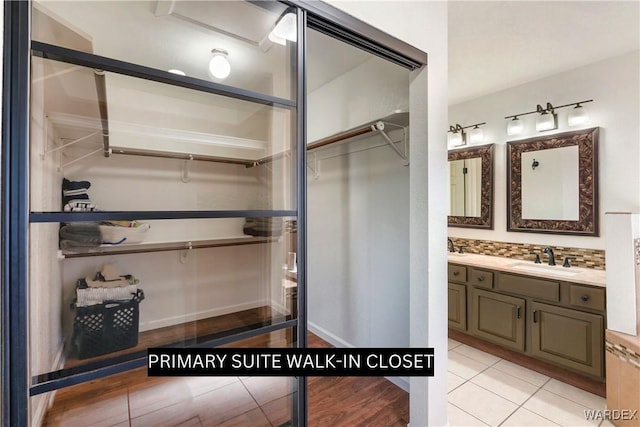 full bathroom featuring tile patterned floors, a spacious closet, decorative backsplash, and vanity