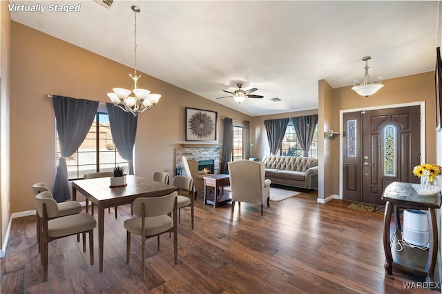 dining space featuring visible vents, baseboards, dark wood-style floors, vaulted ceiling, and a fireplace