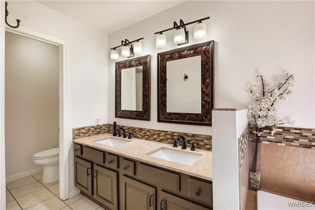 full bath featuring toilet, double vanity, backsplash, and a sink