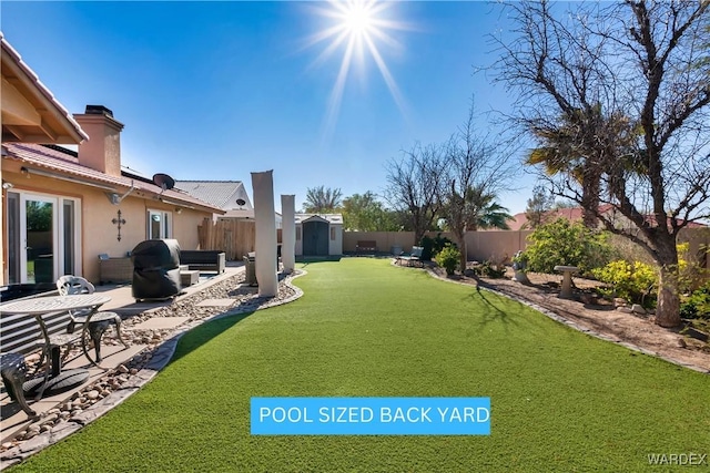 view of yard with a patio area, a fenced backyard, an outdoor structure, and a storage shed