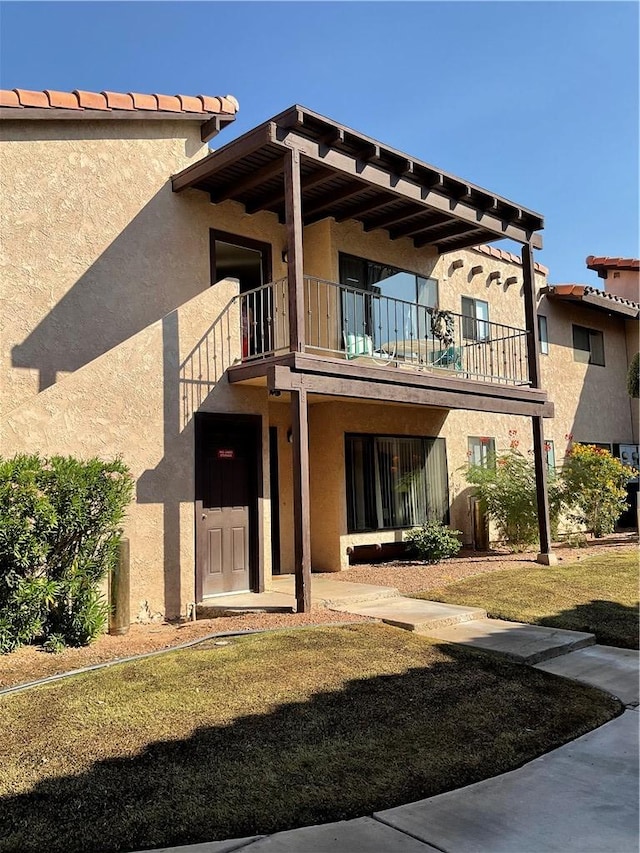 201 Riverfront Drive, Drive, Bullhead City, AZ 86442 - rear view of house with a balcony, stucco siding, and a yard