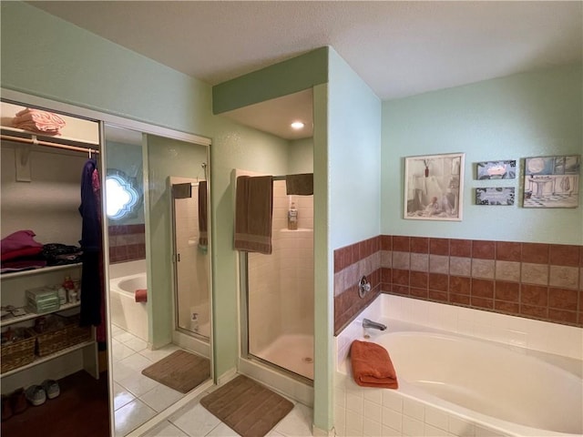 2405 N Clack Canyon Rd, Kingman, AZ 86409 - full bathroom featuring a bath, a walk in closet, tile patterned floors, and a shower stall