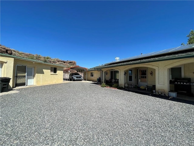 2405 N Clack Canyon Rd, Kingman, AZ 86409 - rear view of house with a carport, solar panels, and stucco siding