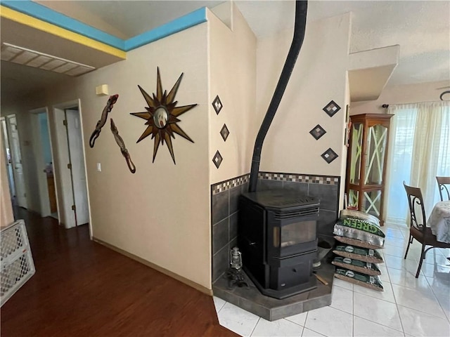 2405 N Clack Canyon Rd, Kingman, AZ 86409 - detailed view of a wood stove, tile walls, wood finished floors, and a wainscoted wall