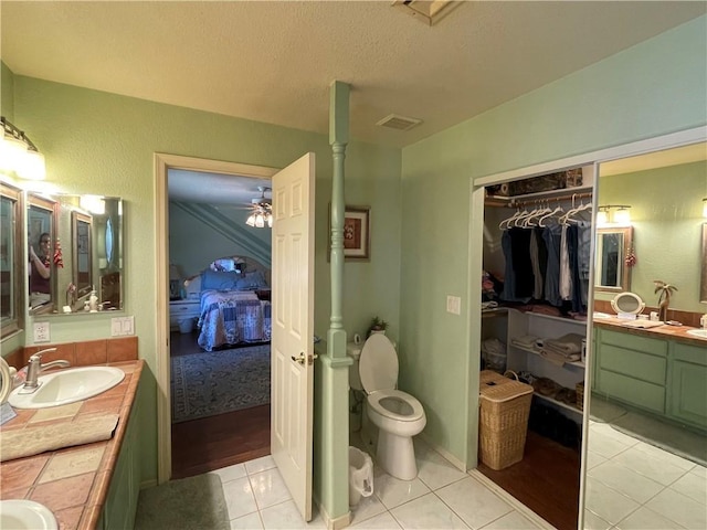 2405 N Clack Canyon Rd, Kingman, AZ 86409 - ensuite bathroom with vanity, tile patterned floors, a textured ceiling, a ceiling fan, and a spacious closet