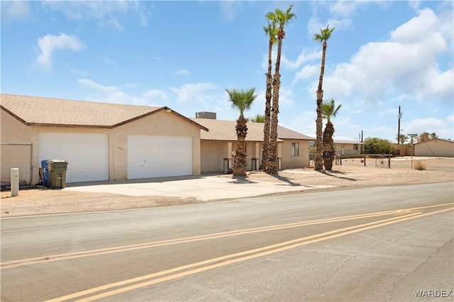 view of front of property with a garage, concrete driveway, and stucco siding