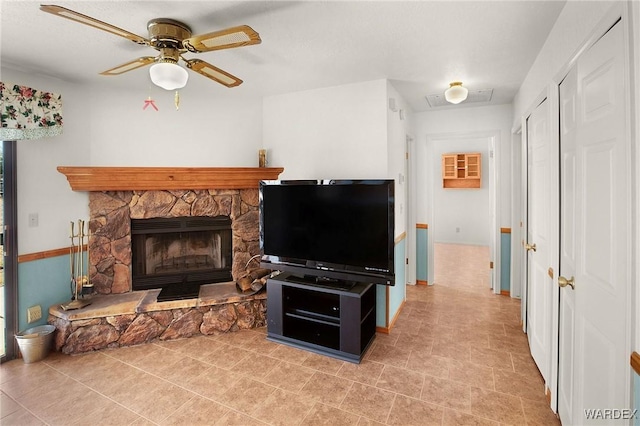 living area featuring a ceiling fan, visible vents, and a fireplace