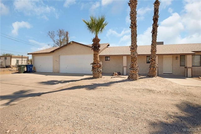 ranch-style home featuring an attached garage, concrete driveway, and stucco siding