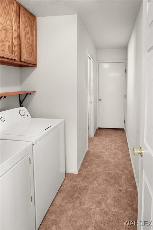 clothes washing area featuring cabinet space, baseboards, and separate washer and dryer