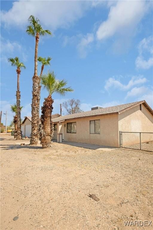 single story home with fence and stucco siding