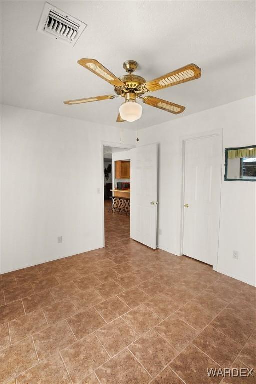 spare room with ceiling fan and visible vents