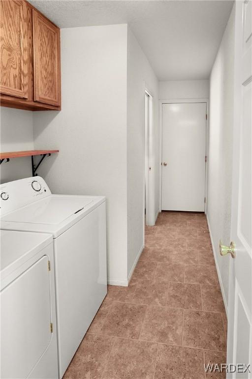 laundry room with cabinet space, baseboards, and independent washer and dryer