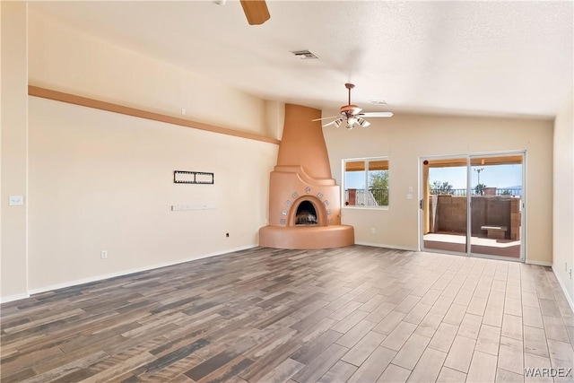 2190 Hijolly Dr, Bullhead City, AZ 86442 - unfurnished living room with visible vents, a large fireplace, a ceiling fan, and wood finished floors