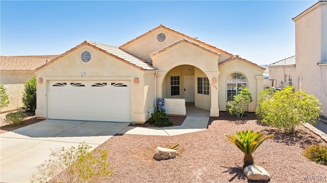 2190 Hijolly Dr, Bullhead City, AZ 86442 - mediterranean / spanish house featuring a garage, stucco siding, concrete driveway, and a tile roof