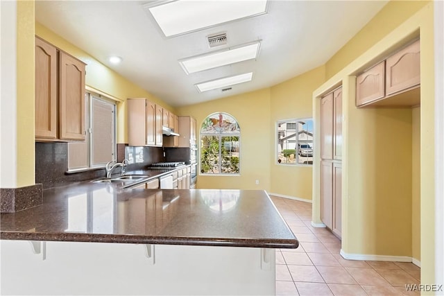 2190 Hijolly Dr, Bullhead City, AZ 86442 - kitchen with visible vents, light tile patterned floors, light brown cabinets, a peninsula, and under cabinet range hood