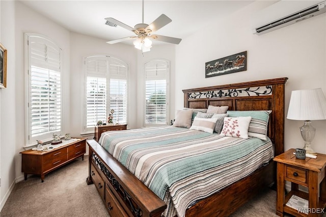 bedroom featuring a ceiling fan, light colored carpet, a wall mounted air conditioner, and multiple windows