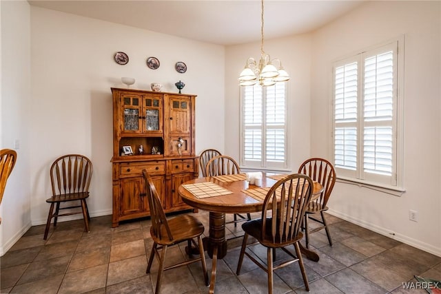 dining room with a chandelier and baseboards